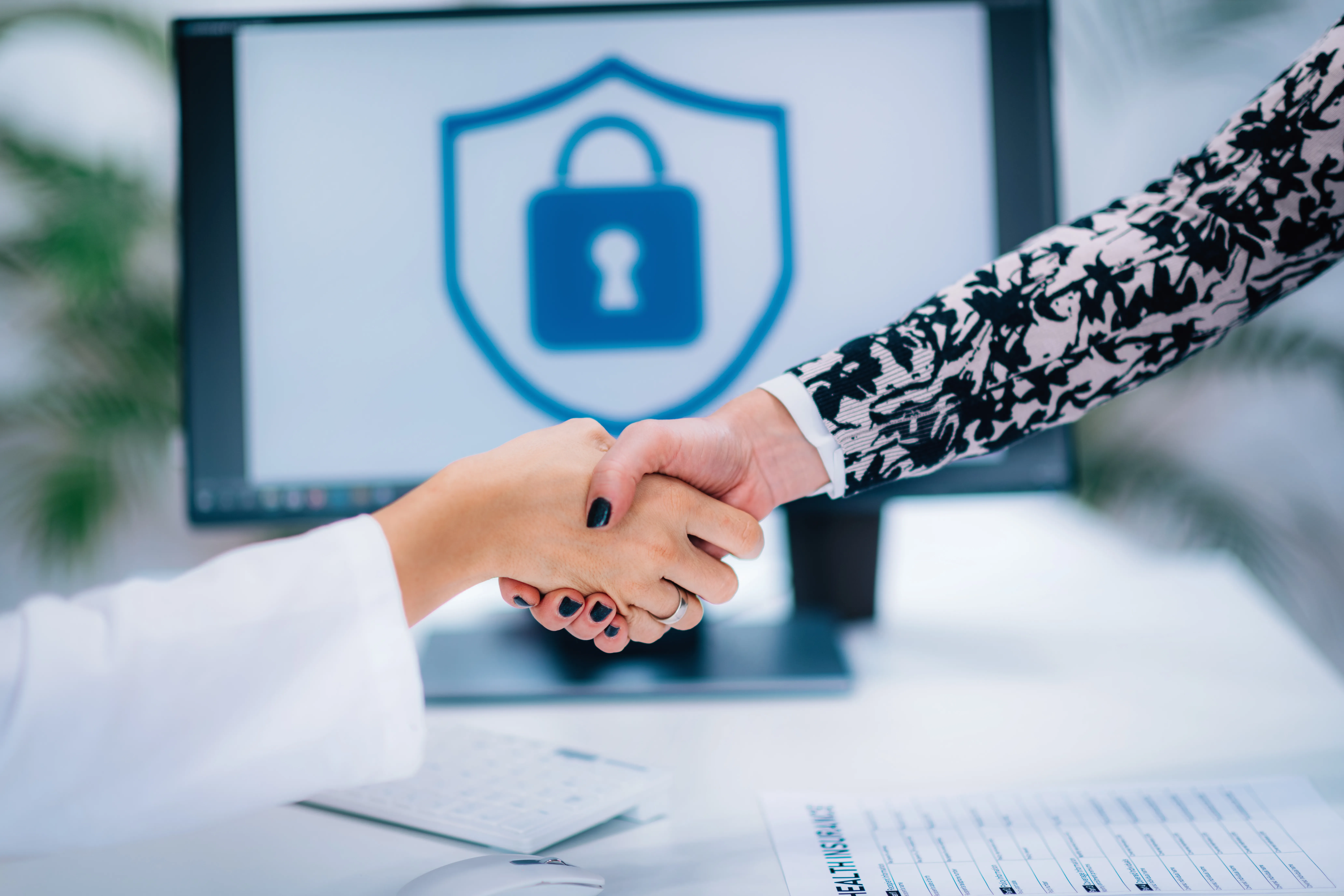 Dos personas estrechando la mano en se&ntilde;al de confianza, seguridad y cumplimiento respaldado por una fianza profesional.