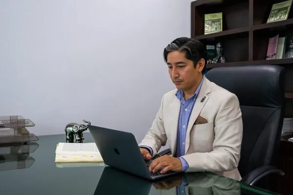 Profesional estudiando y aplicando conocimientos adquiridos del curso ComprasMX. Hombre sentado utilizando una laptop mientras estudia y navega dentro del curso ComprasMX.